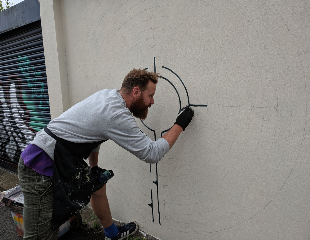 Pelmo painting on wall with a brush
